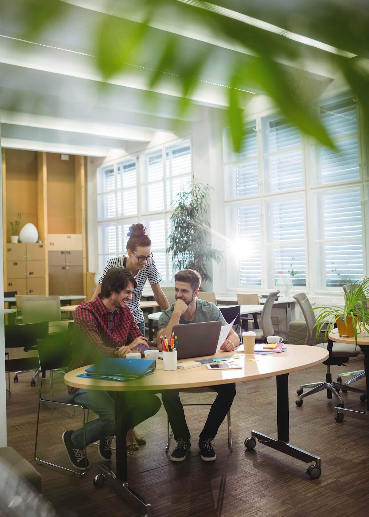 3 Personen in einem Büro, die zusammenarbeiten